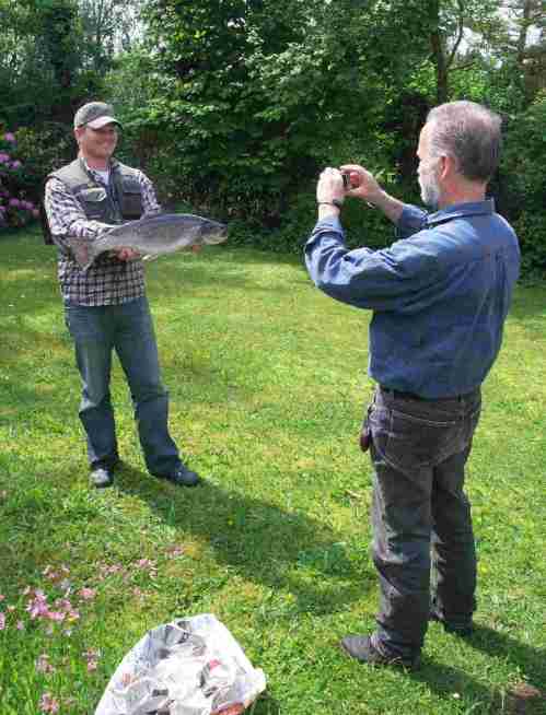 2 Wasserwanderer, einer mit Digicam, einer mit Fisch.