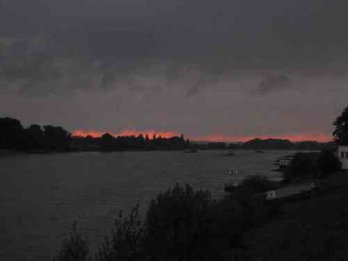Das Wetter war spannend - finstere Gewitterwolken jagen bei Abendrot über den Rhein.