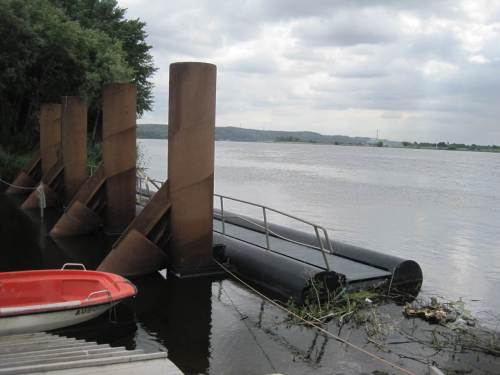 Hier am oberen Ende des Fischpasses hindert ein großer Schwimmabweiser Schwimmendes daran, den Zulauf zu verstopfen. Man spricht von so Schwimmendem bei Hochwasser wie Wohnwagen und ähnlichem.