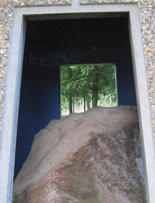 Aufwärts geht es durch den Skulpturenpark, hier: Blick über einen Eiszeitstein ("Findling") auf Waldlandschaft.