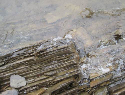 von Wellen umspülte senkrecht stehende messerscharfe Steinformation