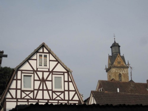 Korbach, sieht alles ganz normal aus - St. Kilian hinter Fachwerkhaus im Morgenlicht.