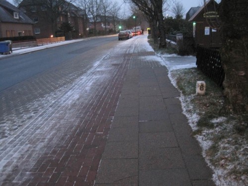 Andere Straße, das selbe Bild - im Hintergrund rückt eine Gartenbau(!)firma an. Mit vollen Händen werden volle Salzeimer schnell geleert. - Diesen Handelnden erlitten eine kleine Fortbildung.  :-)