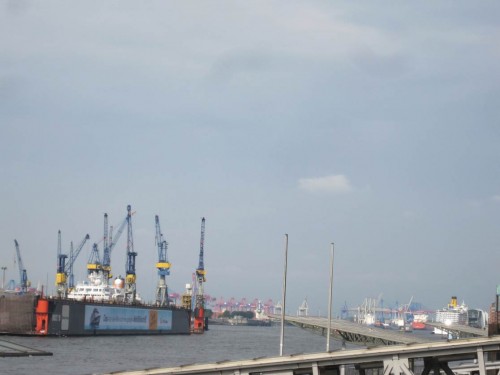 Die Vielzahl Kräne und der Kreuzfahrer rechts am West-Horizont zeigen, dass es offenbar Arbeit im Hafen gibt.