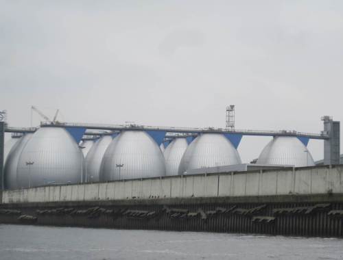 Vorbei geht`s an den Faultürmen für Klärschlamm auf dem Klärwerksgelände Köhlbrandhöft. Im Vordergrund trocknen - unscharf - Kormorane.