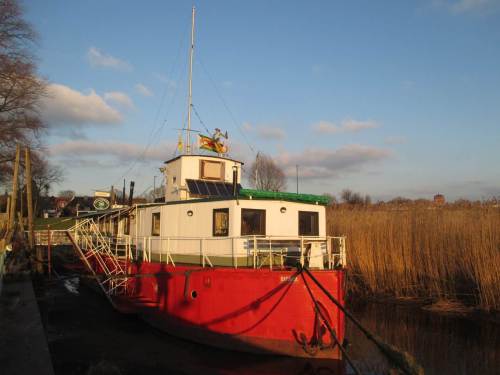 Abendsonne beleuchtet das Theaterschiff Batavia, bei Tideniedrigwasser auf Elbschlick aufliegend.