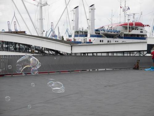 Die Seifenblasen erfreuen auch die Passanten, hoch oben auf der Hochwasserschutzanlage.