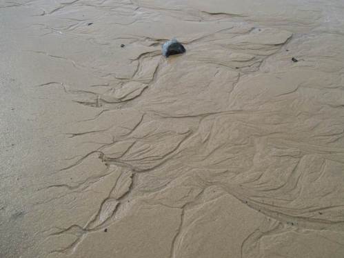 In unzähligen Rinnsalen entwässert die Sandfläche bei Ebbe.