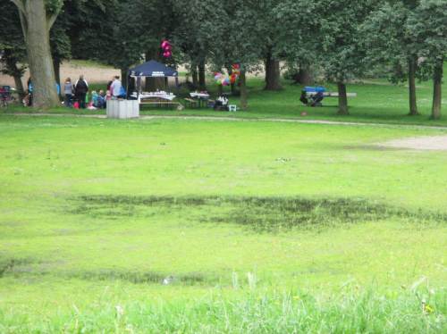 Dränproblem am Fußballplatz - hier ziehen die vorn gezeigten Entwässerungsrinnsale offenbar gar nichts weg. - Im Hintergrund: Anregung für Freiluft-Geburtstagsfeier.
