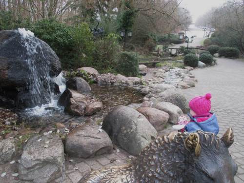 Am Eingang begeistern Groß und Klein eine Wildschwein-Skulptur, die schon ordentlich "golden" gerubbelt ist und ein künstlicher Quellwasserfall mit Bachlauf.